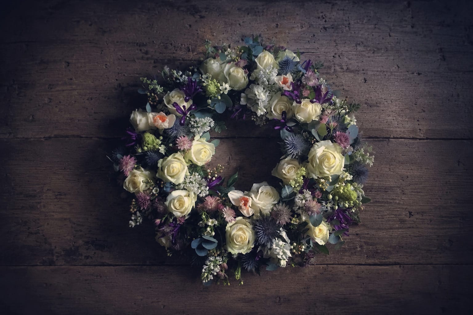 Funeral wreath Funeral wreath in white roses, eucalyptus and sea holly — made by hand at Blomsterringen